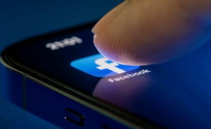 UQ research has found online reporting of minor crime can unjustly stigmatise a neighbourhood, and affect people's use of public spaces offline. Image: Adobe A fingertip pushes on the Facebook App on a mobile phone screen.
